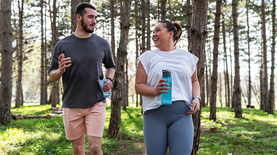 Junges Paar beim Joggen im Wald, Frau etwas übergewichtig