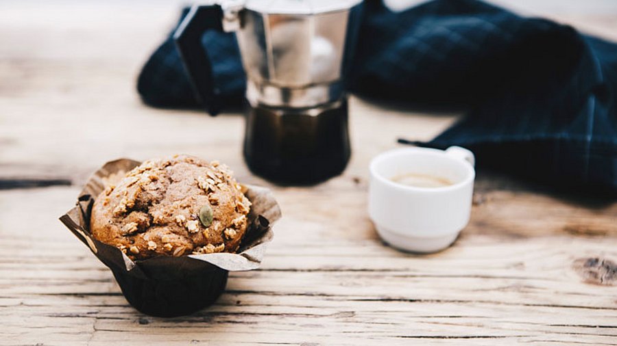 1 Stück Muffin mit Espresso serviert.