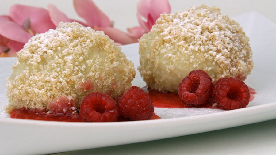 2 gefüllte Knödel mit Himbeeren dekoriert.