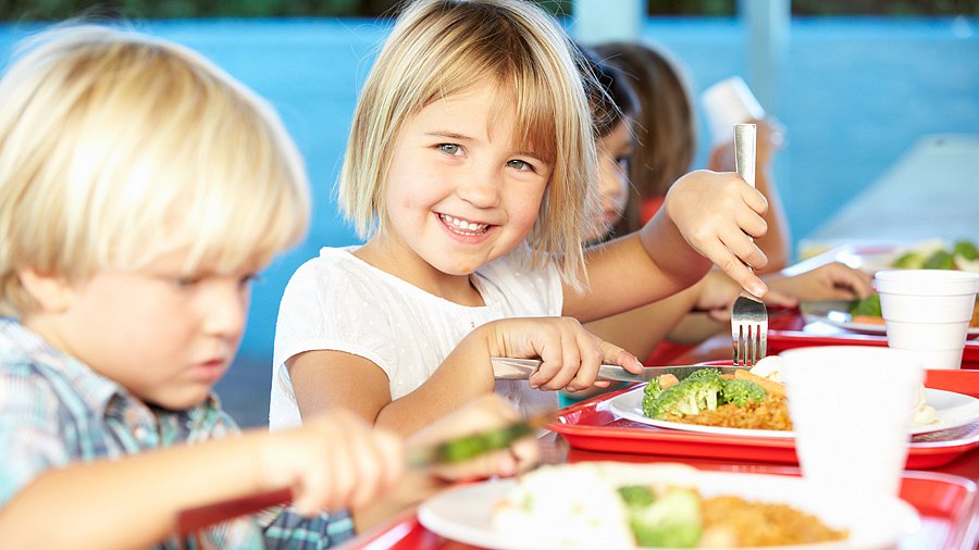 Kinder beim gemeinsamen Mittagessen in einer Grundschule